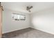 This is a serene bedroom featuring carpet, ceiling fan, window, and a wood sliding door at 14608 N Montego Ct, Phoenix, AZ 85053