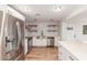 Bright kitchen featuring stainless appliances, a subway tile backsplash, open shelving, and an eat-in quartz countertop island at 14608 N Montego Ct, Phoenix, AZ 85053