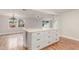 Bright kitchen island featuring a quartz countertop with white shaker cabinets and updated hardwood flooring at 14608 N Montego Ct, Phoenix, AZ 85053