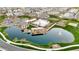 Aerial view of a community with a large pond, pool, clubhouse, playground, and green spaces at 1464 E Aris Dr, Gilbert, AZ 85298