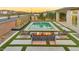 Chic backyard featuring a cozy fire pit area with stylish seating, artificial turf, and a sparkling pool at 1464 E Aris Dr, Gilbert, AZ 85298