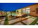 Charming backyard with a pool, fire pit, and beautifully lit landscaping at 1464 E Aris Dr, Gilbert, AZ 85298