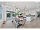 Bright dining room with modern light fixture, open to a gourmet kitchen and sliding glass doors at 1464 E Aris Dr, Gilbert, AZ 85298