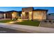 Nighttime view of a house with a stone entryway, lush green grass and desert landscaping at 1464 E Aris Dr, Gilbert, AZ 85298