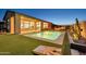 Inviting backyard pool and firepit, great for outdoor relaxation and entertainment, complete with cornhole game on the lawn at 1464 E Aris Dr, Gilbert, AZ 85298