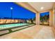 Relaxing evening view of the pool and patio with stylish travertine pavers at 1464 E Aris Dr, Gilbert, AZ 85298