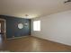 Neutral living room boasts tile flooring and a statement wall with a decorative mirror and modern chandelier at 15257 W Jackson St, Goodyear, AZ 85338