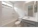 A bright bathroom with a shower-tub combo, modern vanity, and gray cabinets at 17614 W Rancho Dr, Litchfield Park, AZ 85340