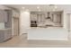 Modern kitchen with grey cabinets, stainless steel appliances, and island with quartz countertops at 17614 W Rancho Dr, Litchfield Park, AZ 85340