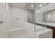 Bright shower with white tile walls, a built-in seat, and a glass enclosure at 17821 W Getty Dr, Goodyear, AZ 85338