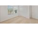 Bright bedroom features a large window, neutral carpet, and a closet with white sliding doors at 17821 W Getty Dr, Goodyear, AZ 85338