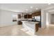 Bright kitchen featuring stainless steel appliances, dark wood cabinets and a large island with granite countertops at 17821 W Getty Dr, Goodyear, AZ 85338