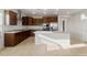 Open kitchen featuring stainless steel appliances, dark wood cabinets, granite countertops and a large center island at 17821 W Getty Dr, Goodyear, AZ 85338
