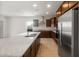Modern kitchen featuring stainless steel appliances, dark wood cabinets, granite counters, and tile flooring at 17821 W Getty Dr, Goodyear, AZ 85338