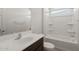 Well-lit bathroom with a shower-tub combo, a vanity with a dark wood cabinet and light countertop at 17845 W Getty Dr, Goodyear, AZ 85338