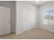 Bright bedroom with carpet, a large window, and closet with mirrored doors, offering ample storage space at 17845 W Getty Dr, Goodyear, AZ 85338