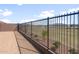 View of black metal backyard fence offering security, with serene park views for relaxation and nature at 17845 W Getty Dr, Goodyear, AZ 85338