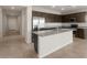 Modern kitchen with dark wood cabinets, stainless steel appliances, and large island at 17845 W Getty Dr, Goodyear, AZ 85338
