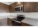 Close up of the stainless steel microwave and oven with granite countertops at 17845 W Getty Dr, Goodyear, AZ 85338