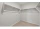 Spacious walk-in closet with carpeted floor and shelving perfect for organizing wardrobe and storage at 17845 W Getty Dr, Goodyear, AZ 85338