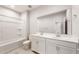 Bright bathroom featuring a double sink vanity, large mirror, and a shower-tub combo for a modern aesthetic at 17851 W Getty Dr, Goodyear, AZ 85338