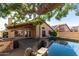 A pristine pool, covered patio, and large shade tree create a relaxing backyard oasis at 18525 N 85Th N Ave, Peoria, AZ 85382
