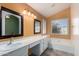 Bathroom featuring a large vanity, dual mirrors, and a bathtub at 18525 N 85Th N Ave, Peoria, AZ 85382
