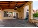 Covered patio with stone flooring, ceiling fans, and access to the backyard pool; ideal for outdoor entertaining at 18525 N 85Th N Ave, Peoria, AZ 85382