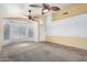 A bright living room with tile and carpet flooring, neutral walls, and a ceiling fan at 18525 N 85Th N Ave, Peoria, AZ 85382