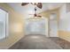 A bright living room with tile and carpet flooring, neutral walls, and a ceiling fan at 18525 N 85Th N Ave, Peoria, AZ 85382
