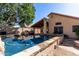 Inviting backyard pool with outdoor kitchen, lush landscaping, and a covered patio, perfect for entertaining at 18525 N 85Th N Ave, Peoria, AZ 85382
