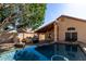 Inviting backyard pool with outdoor kitchen, lush landscaping, and a covered patio, perfect for entertaining at 18525 N 85Th N Ave, Peoria, AZ 85382