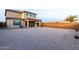 Expansive backyard with neutral gravel, mature trees, and views of the two-story home at 19703 W Badgett Ln, Litchfield Park, AZ 85340