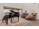Open living room with piano, tall ceilings, large windows, tile floor, and elegant furnishings at 19703 W Badgett Ln, Litchfield Park, AZ 85340
