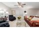 Cozy living room featuring a plush leather sofa, accent chairs, and natural light, perfect for relaxation at 19703 W Badgett Ln, Litchfield Park, AZ 85340