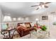Upstairs living room with comfortable leather sofa, ceiling fan, and bright lighting at 19703 W Badgett Ln, Litchfield Park, AZ 85340