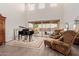 Open living room with piano, tall ceilings, large windows, tile floor, and elegant furnishings at 19703 W Badgett Ln, Litchfield Park, AZ 85340