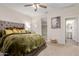 Spacious main bedroom with a comfortable bed, ceiling fan, and ensuite bathroom access at 19703 W Badgett Ln, Litchfield Park, AZ 85340