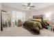 Comfortable main bedroom with a plush bed, ceiling fan, and mirrored dresser at 19703 W Badgett Ln, Litchfield Park, AZ 85340
