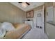 Charming bedroom featuring gold patterned wallpaper, a ceiling fan, and soft carpeting at 20766 W White Rock Rd, Buckeye, AZ 85396
