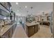 Open floor plan showcases the kitchen with stainless steel appliances and island with breakfast bar at 20766 W White Rock Rd, Buckeye, AZ 85396