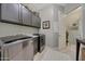 Well-equipped laundry room with gray cabinetry and modern washer and dryer at 20766 W White Rock Rd, Buckeye, AZ 85396