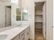 Bathroom with a double sink vanity with quartz countertops and a walk-in closet at 2113 N 210Th Ave, Buckeye, AZ 85396