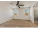 Bright bedroom with two windows, neutral carpet, and a ceiling fan at 2113 N 210Th Ave, Buckeye, AZ 85396