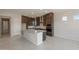 Gourmet kitchen with dark cabinets, stainless steel appliances, a center island, and modern fixtures at 26161 S 225Th Way, Queen Creek, AZ 85142