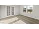 Bright room with French doors, neutral carpet, baseboards, and trim with large windows providing ample natural light at 2681 N Riverside Dr, Florence, AZ 85132