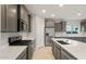 Modern kitchen featuring stainless steel appliances, gray cabinets, a large island with countertop, and stylish travertine tile at 2681 N Riverside Dr, Florence, AZ 85132