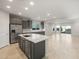 Spacious open-plan kitchen with stainless steel appliances, grey cabinets, large island, and travertine-style tile floors at 2681 N Riverside Dr, Florence, AZ 85132