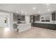 Bright, open kitchen with stainless steel appliances, grey cabinetry, a center island, and travertine-style tile flooring at 2681 N Riverside Dr, Florence, AZ 85132