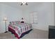 Simple bedroom with a bed featuring a red, white, and blue plaid comforter, illuminated by natural light at 30066 N Holly Dr, San Tan Valley, AZ 85144